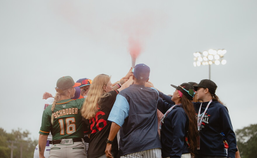 WPBL teams' captains and the league's commissioner, Justine Siegal, pass a torch to youth representatives of Baseball For All, a gender equity initiative to support girls in baseball, in Springfield, Ill., on Saturday, Aug. 1.