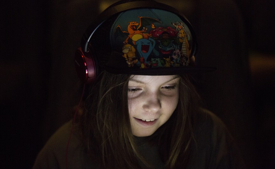 Mia Rossa, 10, sits glued to her screen as she plays Minecraft at the theater.
