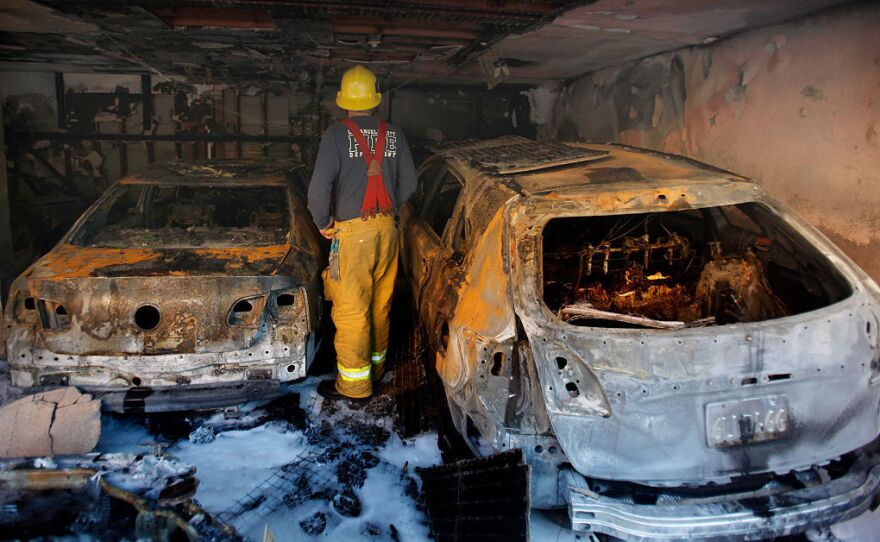 Los Angeles Fireman Matthew Hills looks at the damage done to an apartment complex on the morning after an arson fire destroyed two units and four cars in Hollywood on Dec. 29, 2011.