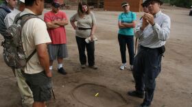 William Suzbach, a senior tracker with the nonprofit San Diego Tracking Team, talks to a group of volunteer recruits at Los Peñasquitos Ranch House in North County how to determine what kind of animal left a track in the dirt. 