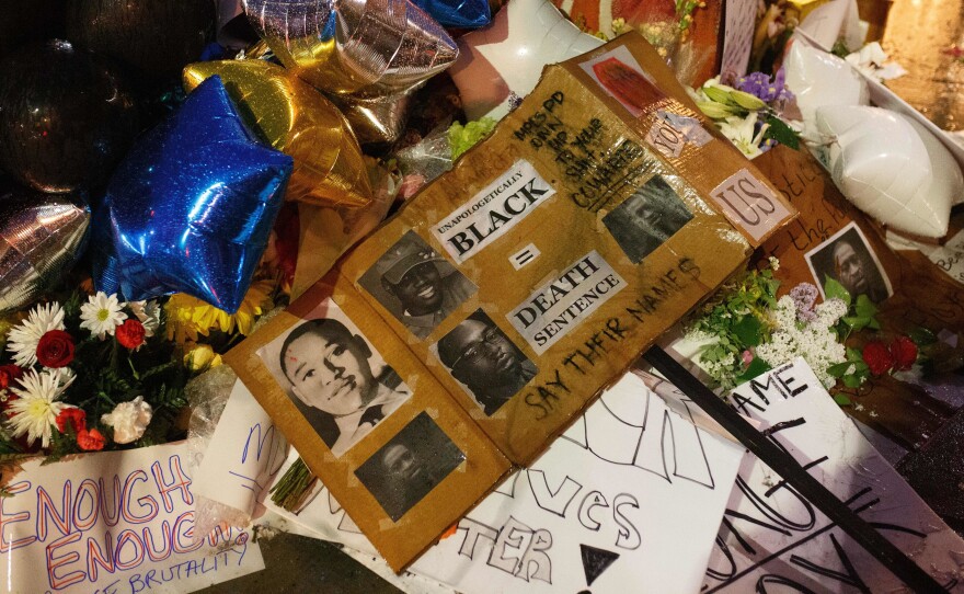 A makeshift memorial, seen Tuesday, has grown near where George Floyd died while in the custody of Minneapolis police. Mourners have brought flowers, signs and balloons to the site in Floyd's memory.