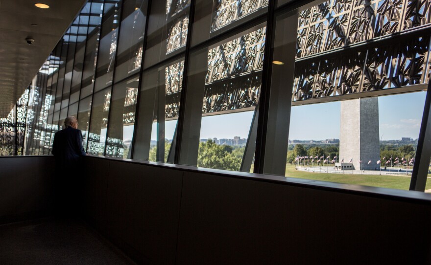 A visitor takes in a view of the National Mall through the panorama window at the NMAAHC.