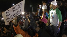 Lesley McSpadden, the mother of Michael Brown, left, standing on the top of a car, reacts as she listens to the announcement that a grand jury decided not to indict the Ferguson police officer Darren Wilson in the fatal shooting of her unarmed son, Nov. 24, 2014.
