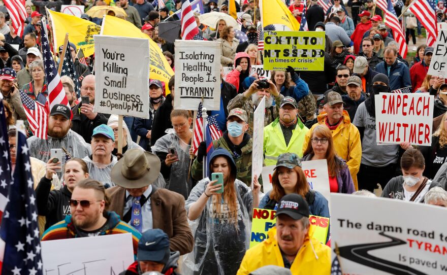 Demonstrators take part in a rally organized Thursday by Michigan United for Liberty on the steps of the Michigan State Capitol in Lansing, demanding the reopening of businesses.