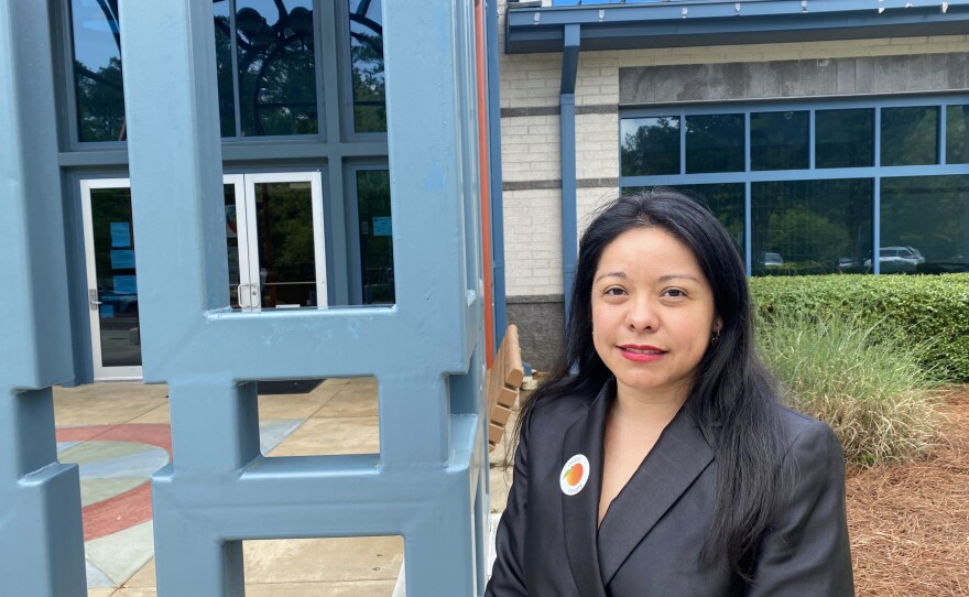 Brenda Lopez Romero, Democratic Party chair in Gwinnett County, stands in front of an early voting center outside Norcross, Ga.