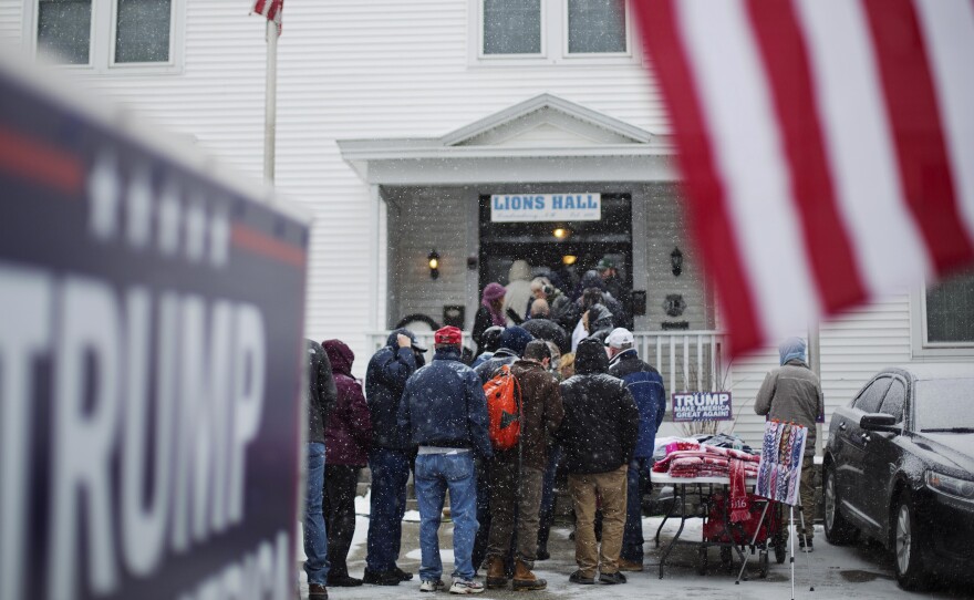 People wait in line amid falling snow to enter a Monday campaign event for Republican presidential candidate Donald Trump at the Lions Club in Londonderry, N.H.