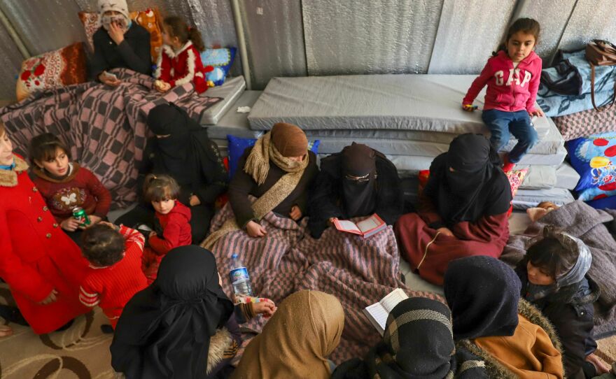 Syrian women recite prayers at an emergency shelter in the center of the city of Maarat Misrin, Syria, in the rebel-held northern part of the northwestern Idlib province one day after a deadly earthquake hit Syria and Turkey, on Tuesday.