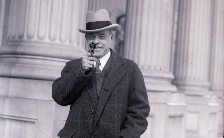 Nicholas Longworth, speaker of the House, holds a gun once owned by famous outlaw Jesse James on Jan. 23, 1930.