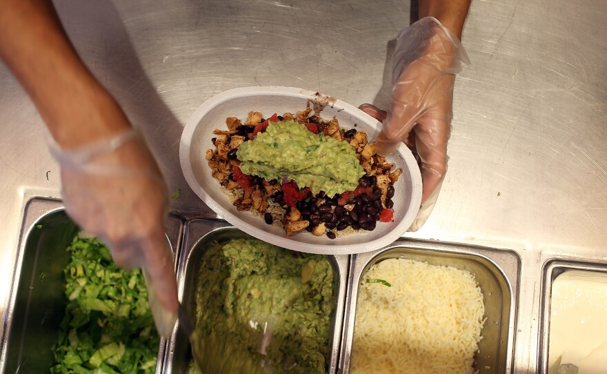 Chipotle restaurant workers fill orders for customers in Miami, Fla., on April 27, 2015, the day that the company announced it will only use non-GMO ingredients in its food.