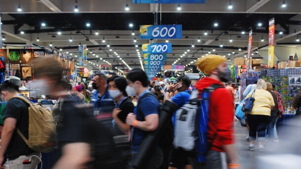 Hundreds of mask-wearing attendees throng the floor at Comic-Con 2022