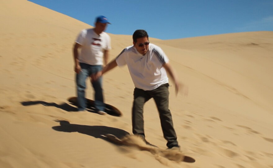 Host Jorge Meraz goes sandboarding down the sand dunes in the small town of Algodones, Baja California, Mexico.