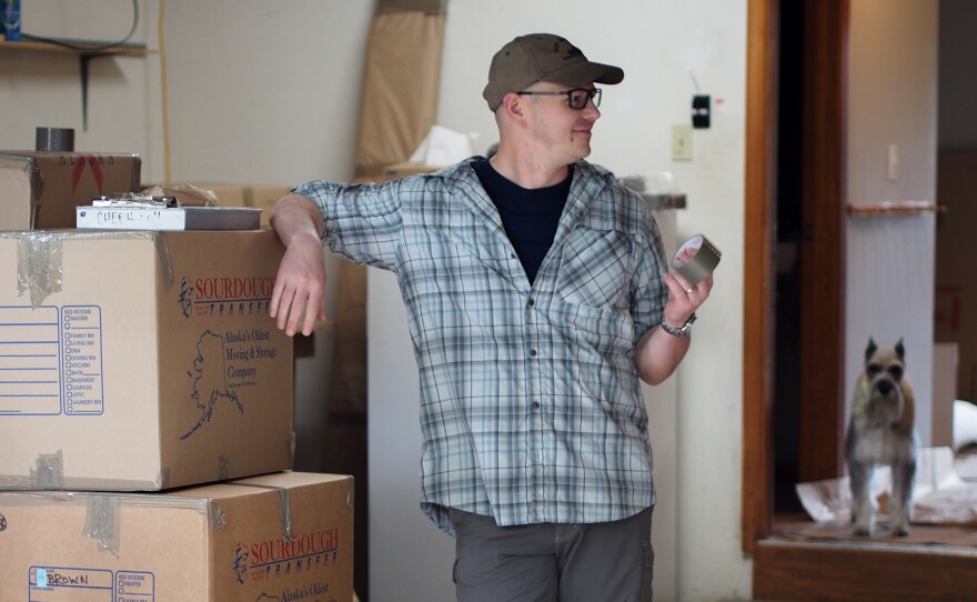 Lt. Col. Alan Brown stands in his garage, filled with boxes that will be sent to the family's new home in New York. In the background is Lucy, the family's Schnauzer.