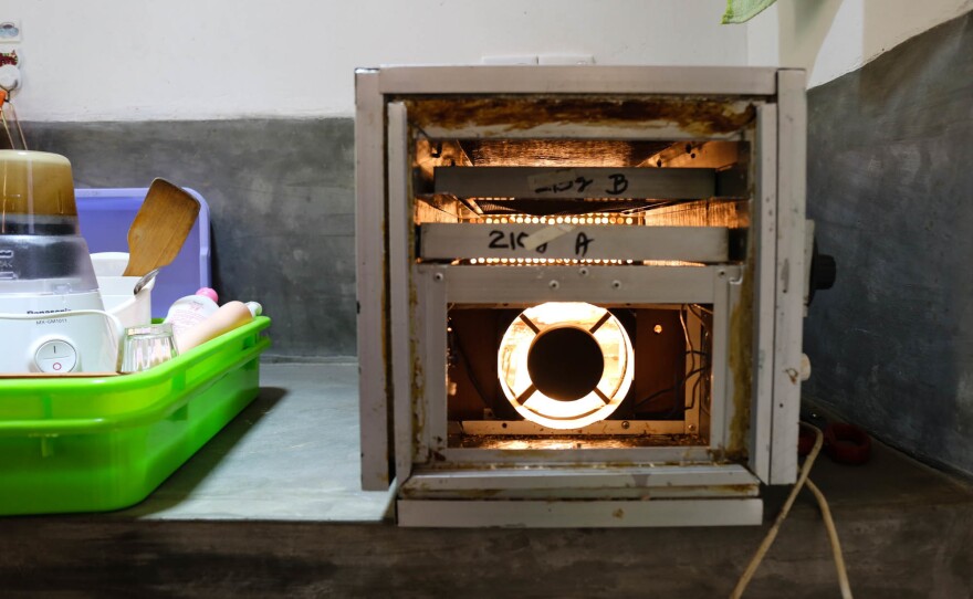 A locally made and designed dryer uses simple technology — a heating bulb and ventilation holes — to dry tea. The machine was designed to be easily replicated by other local farmers.