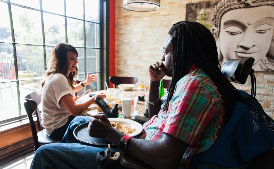 During lunch with his friend Jacquelyn Croudy, Nnaka asks the server for a tray so that he can keep his food in his lap; he says that's easier than trying to get his legs under the table.