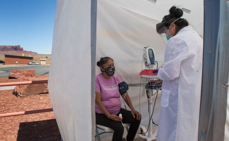 A nurse checks vitals for a Navajo woman, who came to a COVID-19 testing center in Arizona, complaining of virus symptoms.