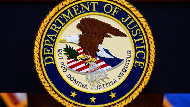 The U.S. Department of Justice logo is seen on a podium before a news conference at the Justice Department in Washington, on May 6, 2025.
