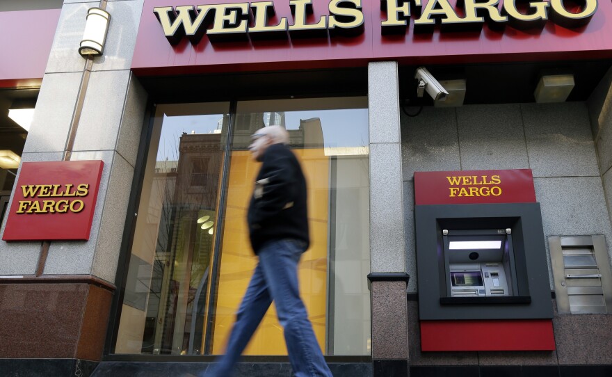 A man walks past a Wells Fargo branch in Philadelphia. The banking company says it wants to make good by its customers, but figuring out how to do that will be a tall task.
