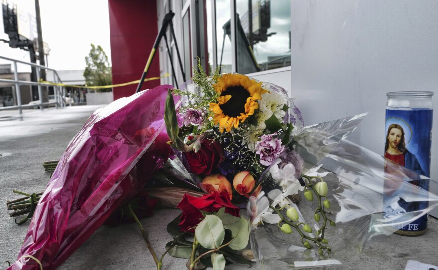 A candle and flowers are left for a teen who was fatally shot at a department store in the North Hollywood section of Los Angeles.