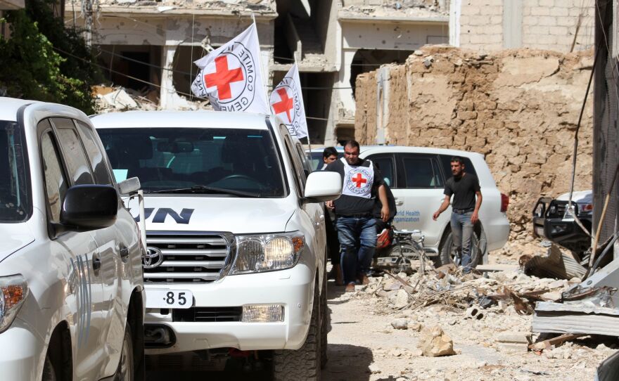 Vehicles of the International Committee of the Red Cross and the United Nations wait after an aid convoy entered the rebel-held town of Daraya, near Damascus, on June 1. It was the first such delivery since a government siege began in 2012, the Red Cross said. But the opposition said only medical supplies were in the delivery, not desperately needed food.