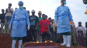People dressed in protective gear prepare to lower into a grave the coffin containing the remains of 3-year-old Mave Mercienne, who died of Ebola, in Bunia, Ituri province, eastern Congo, Tuesday, Aug. 18, 2026.