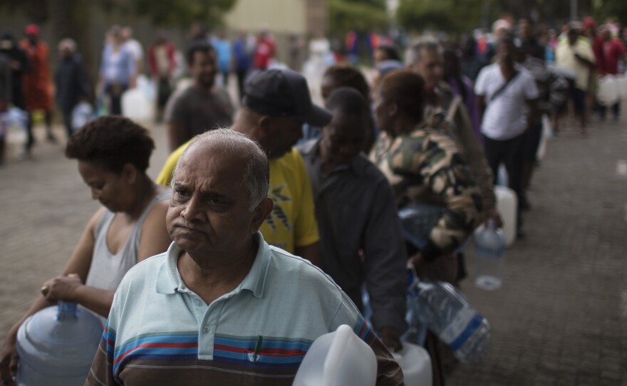 Residents wait to fill containers at a source for natural spring water in Cape Town.