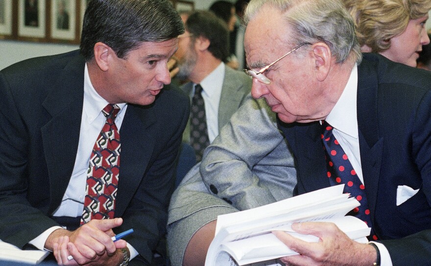 Media magnate Rupert Murdoch, right, huddles with Preston Padden, president of network distribution for Fox, during a hearing of the Federal Communications Commission in May 1995. A generation later, Padden says Murdoch is unfit to hold the licenses for local television stations due to Fox News.