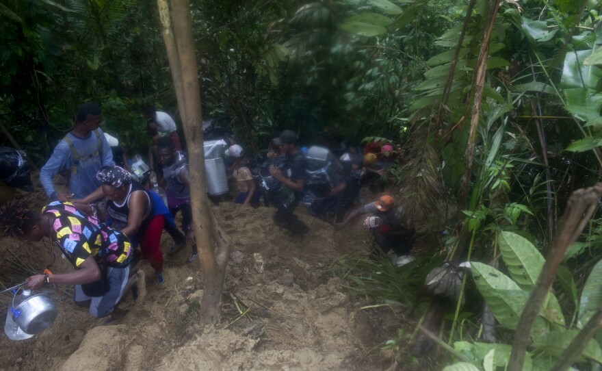 Migrants climb the hilly route through the Darién jungle in challenging conditions with muddy trails and rain in September.