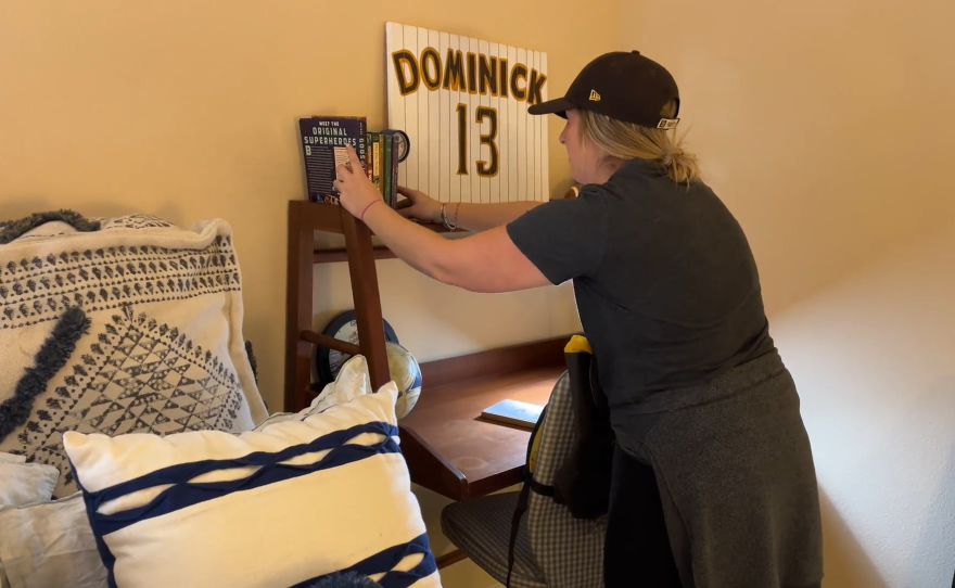 Courtney Brown with Humble Design San Diego arranges books next to a San Diego Padres' themed sign inside a Chula Vista, CA apartment on December 12, 2024.