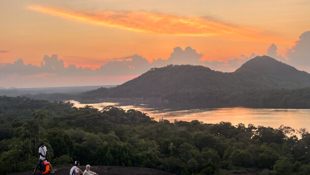 Sunset casts a warm glow over Colombia's remote Mavecure Mountains, where three towering rock formations rise above the Amazon jungle.