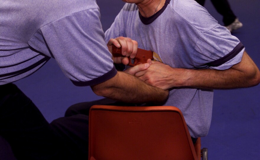 Participants in the first class of commercial airline pilots who volunteered to carry handguns learn defense tactics on April 17, 2003, in Glynco, Ga., as part of the TSA's federal flight deck officer training program. The inaugural group of federal flight deck officer candidates spent the week learning how to use a handgun and defensive tactics.