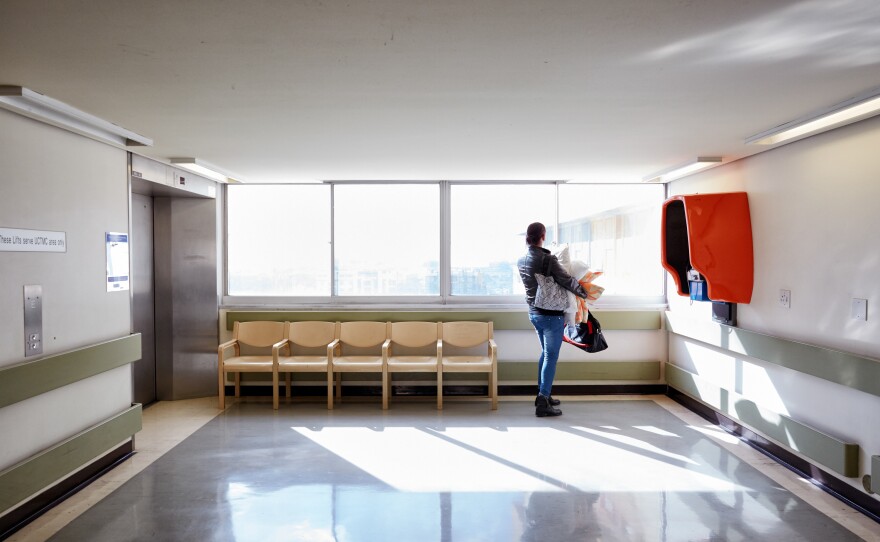 Chedino waits to take an elevator to the plastics ward at the Groote Schuur Hospital in Cape Town, South Africa, in 2017. It took Chedino several hours of signing papers and getting documents stamped before she was finally assigned a bed.