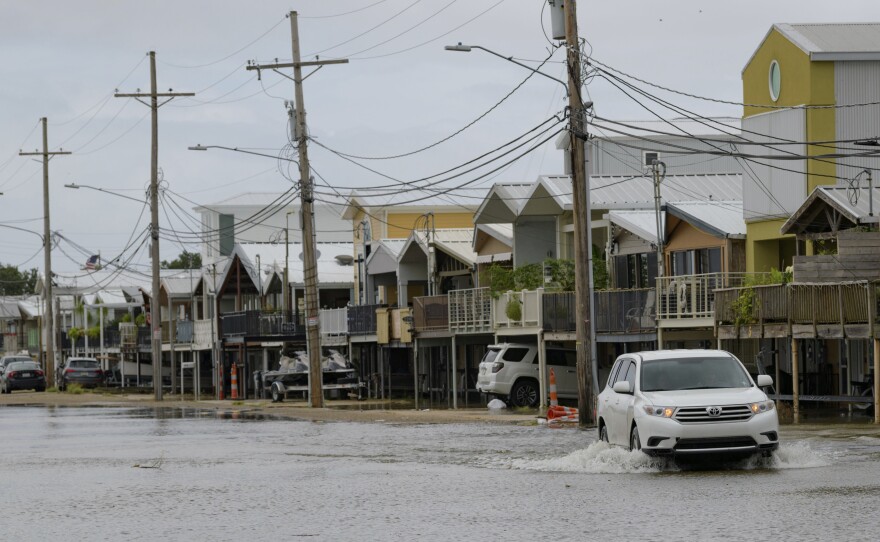 The storm surge from Tropical Storm Barry started pushing water into areas around Lake Pontchartrain Friday, as the storm slowly moved toward shore. Here, an SUV travels down Breakwater Drive near the Orleans Marina in New Orleans. The area is behind a flood wall that protects the rest of the city.