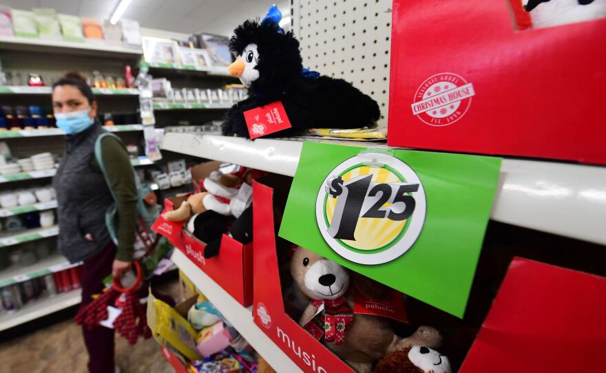 A shopper walks by a sign displaying a $1.25 price tag that was posted on the shelves of a Dollar Tree store in Alhambra, Calif., on Dec. 10, 2021.