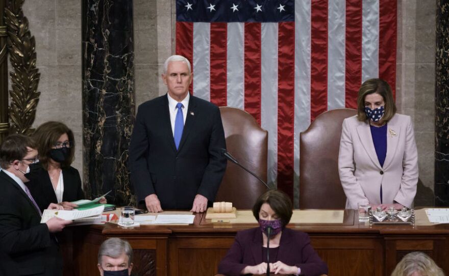 Vice President Mike Pence and Speaker of the House Nancy Pelosi, D-Calif., read the final certification of Electoral College votes cast in November's presidential election, hours after a pro-Trump mob broke into the U.S. Capitol.