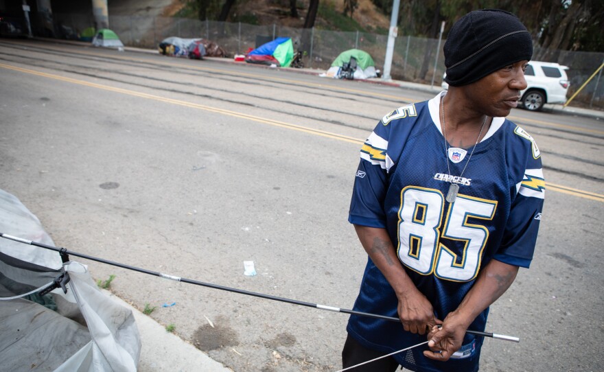 Warren Zevon Riddle breaks down his tent during an enforcement sweep on Commercial Street in San Diego, Calif. June 9, 2022. He plans to move to Market Street.