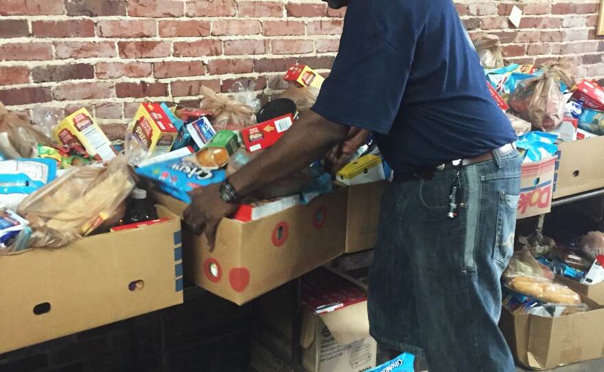 Siegfried Powell moves boxes of food at a food pantry set up in the United Steelworkers Union in Birmingham, Ala. He was laid off from his job at Fairfield Works mill after working there for 26 years.