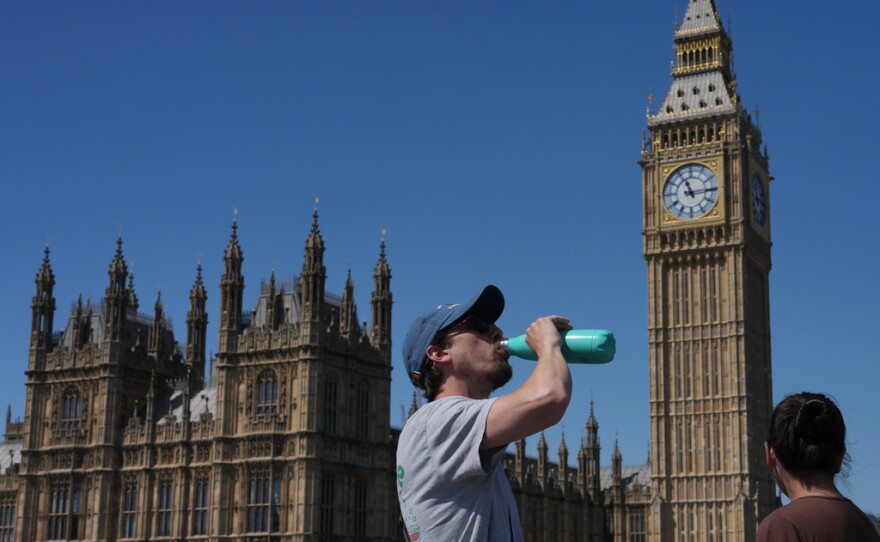 A man drinks Tuesday outside the Palace of Westminster in London.