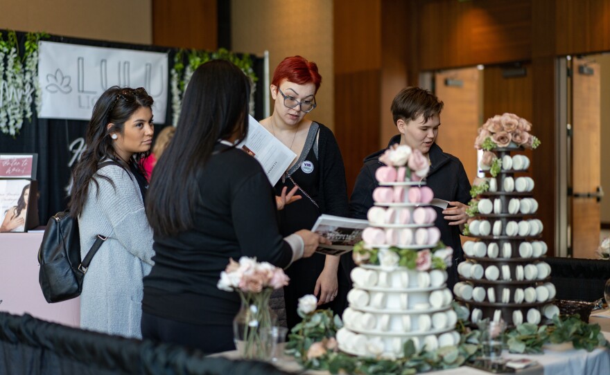 Ashley Lydon (center), checking out macaroon options at the Mariela's Sweets booth during the Great Bridal Expo in Boston, says after two years of pandemic restrictions, she's planning a wedding that will be "over the top." She came with Cheryl Carey, (right) her matron of honor, and Hannah Lydon, her maid of honor (left).