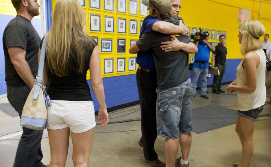 Members of the Prescott fire department embrace as they arrive to listen in at a news conference, Monday, July 1, 2013 in Prescott, Ariz.