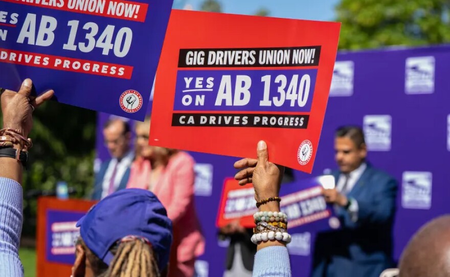 Boxinett King, executive board member of SEIU Region 5, holds up a sign during rally announcing new legislation that allows ride-hail drivers to join a union, at the state Capitol in Sacramento on April 8, 2025. 