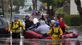 First responders rescue flood-stranded people in Little Ferry, N.J., on Tuesday.