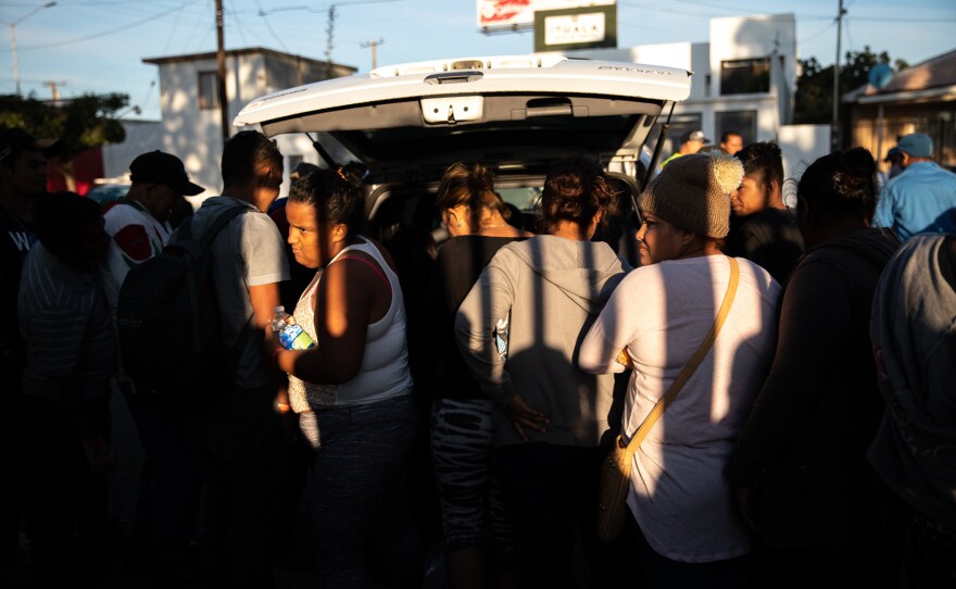 Migrants wait in a line as volunteers donate food in northern Tijuana. With city resources thinly spread, citizens answered the call by offering things like winter clothing and food.
