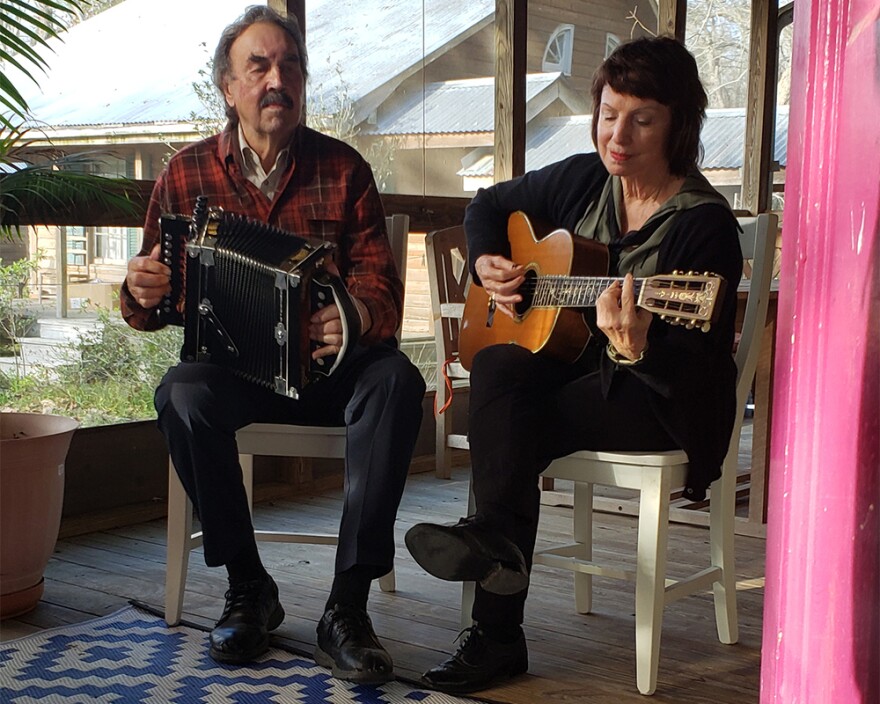 Marc Savoy on accordion and Ann Savoy on guitar playing on their porch