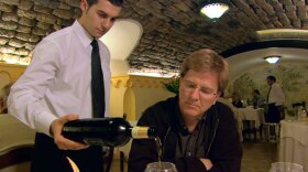 Rick Steves enjoys some wine with dinner while in Italy.