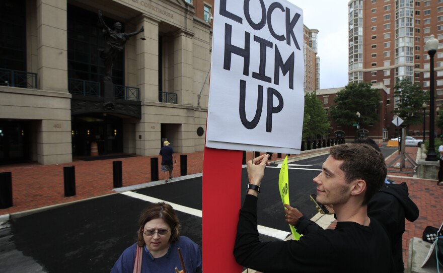 Gayelynn Taxey and Danny Hastings protest in front of the federal courthouse in Alexandria, Va., Tuesday.
