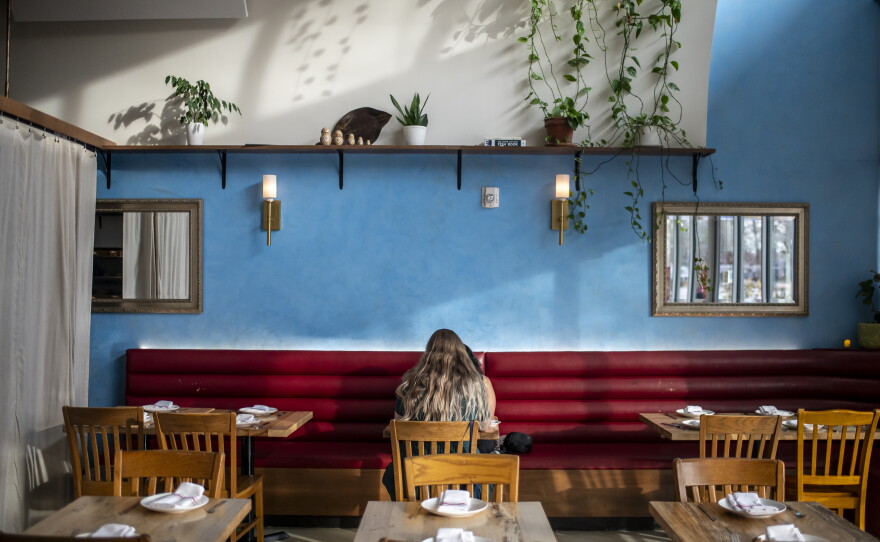 Two guests sit at a table at L'Oca d'Oro. More than a third of Americans are dining out less often than they did last year, according to report from YouGov.