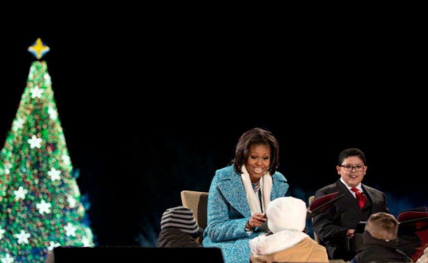 First Lady Michelle Obama reads “’Twas the Night Before Christmas” with Rico Rodriguez to children onstage during the lighting of the National Christmas Tree event on the Ellipse in Washington, D.C., Dec. 6, 2012.