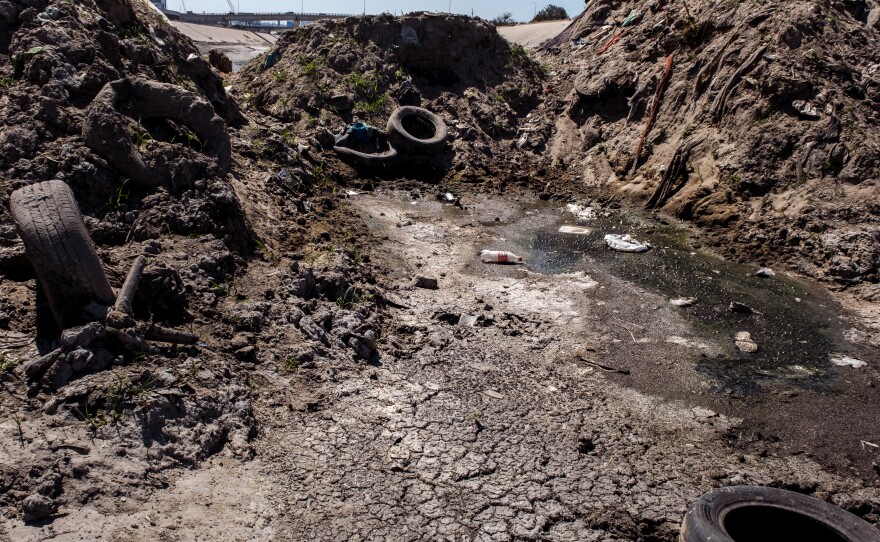 An earthen berm made up of dirt and debris blocks the flow of waster from Mexico into the United States in the Tijuana River, June 14, 2022.