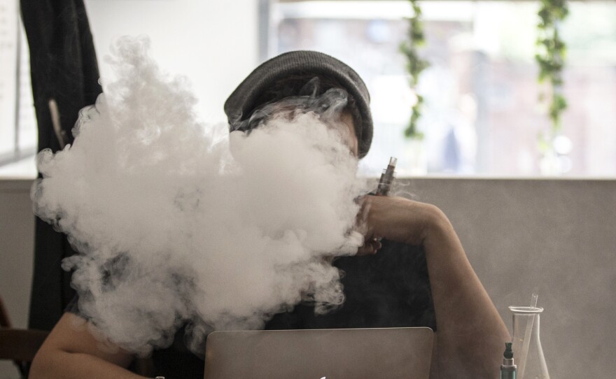 Vapor from an e-cigarette obscures the user's face in a London coffee bar in August.