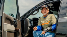 Acy Cooper eats lunch out of his pickup truck at the Myrtle Grove Marina in Port Sulphur, La. on Friday, May 15, 2026. Cooper had just returned to the marina after a shift ferrying oil rig workers from offshore platforms — a job he's taken because of falling shrimp prices and increasing fuel costs.